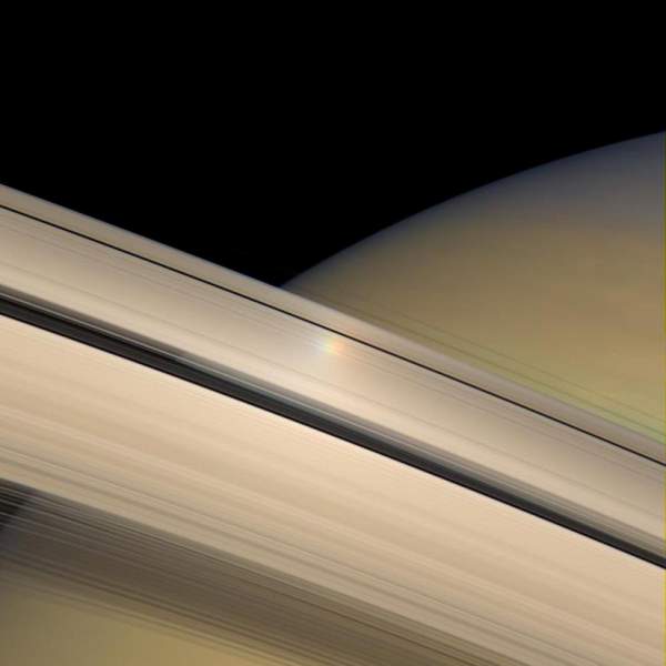 Un riflesso iridescente della luce solare sugli anelli di Saturno